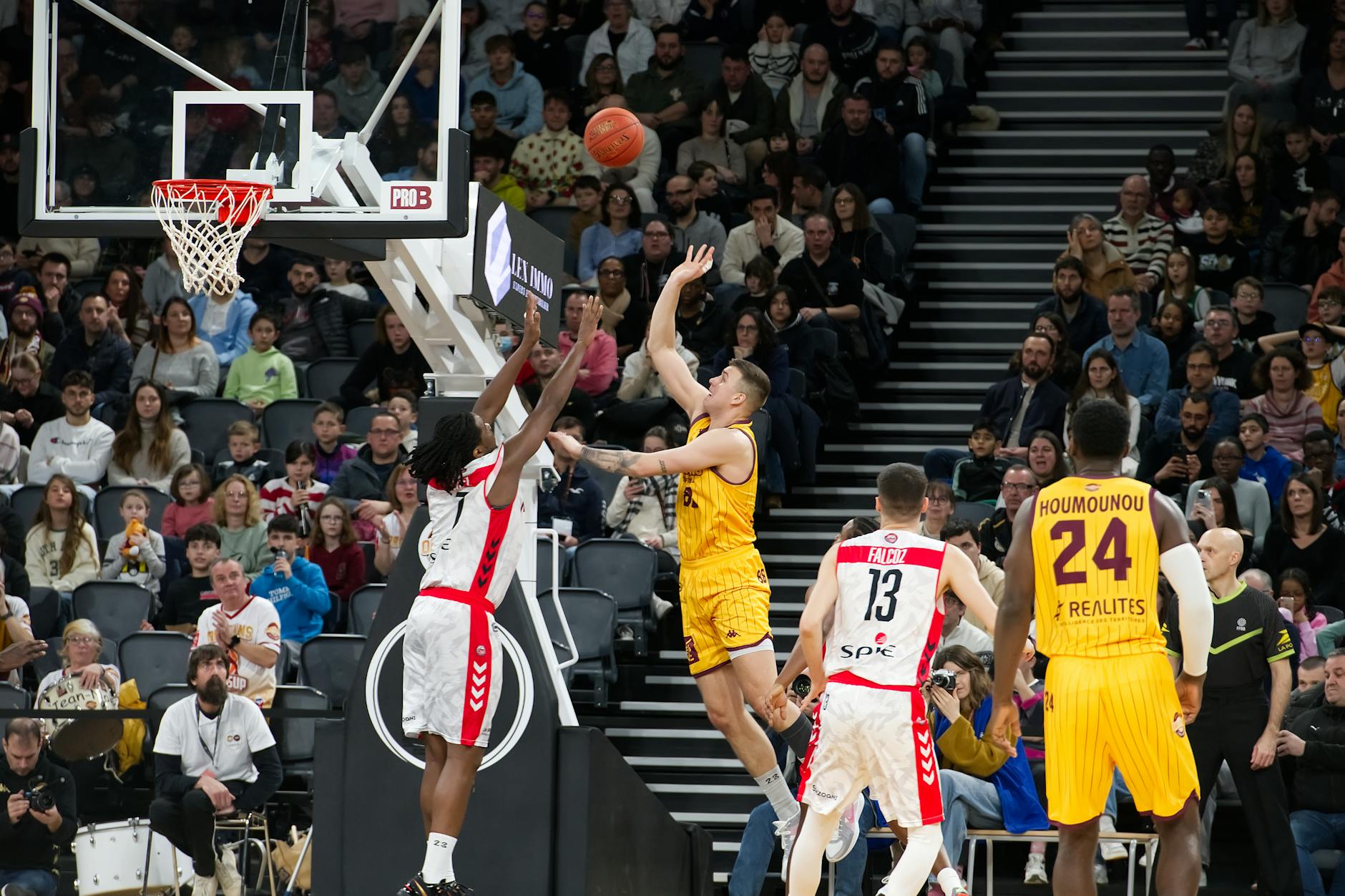 Dramatic moment in a basketball game with players and an engaged crowd.