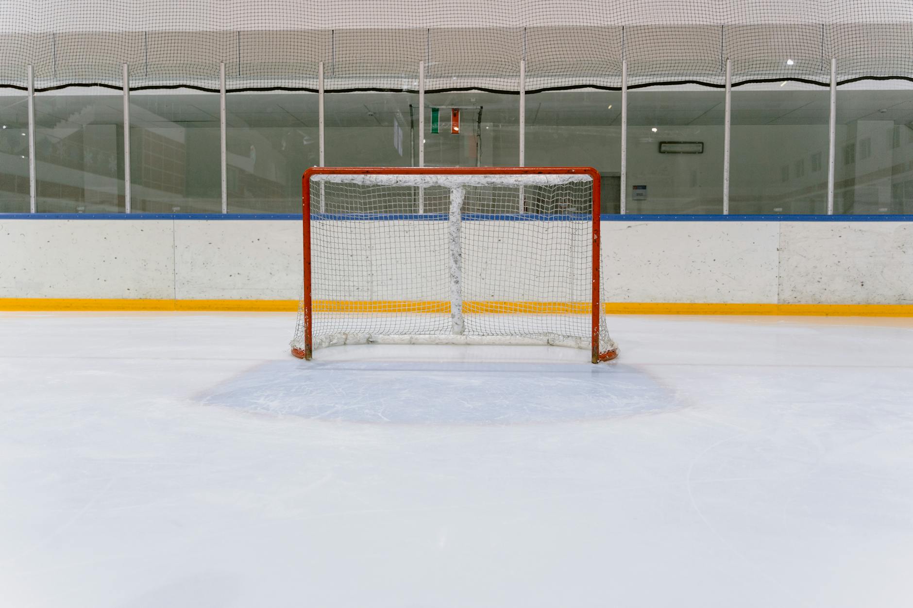 Ice hockey rink with a centered goal net, ideal for sports themes.