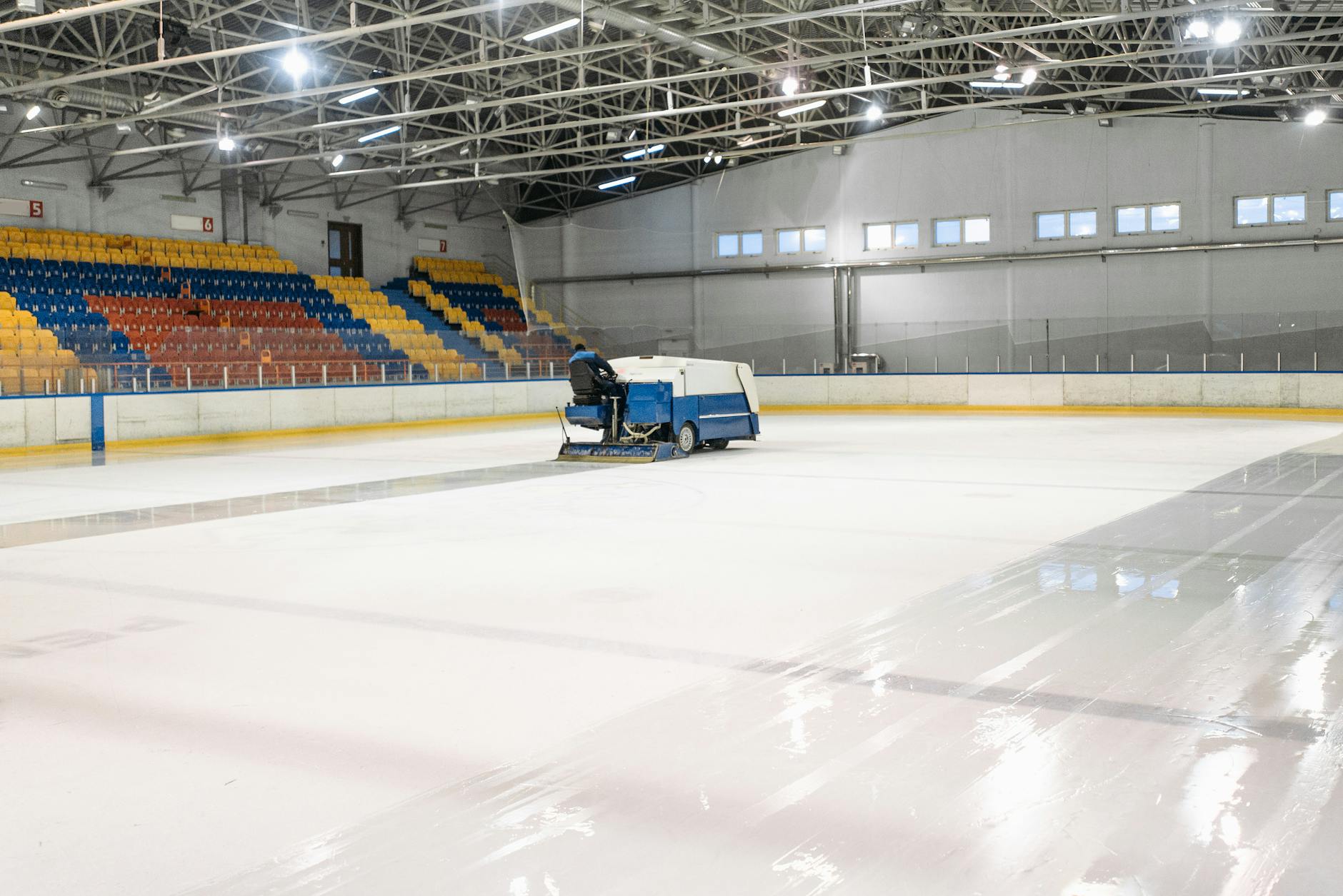 An ice resurfacer smooths the surface of an indoor ice skating rink.