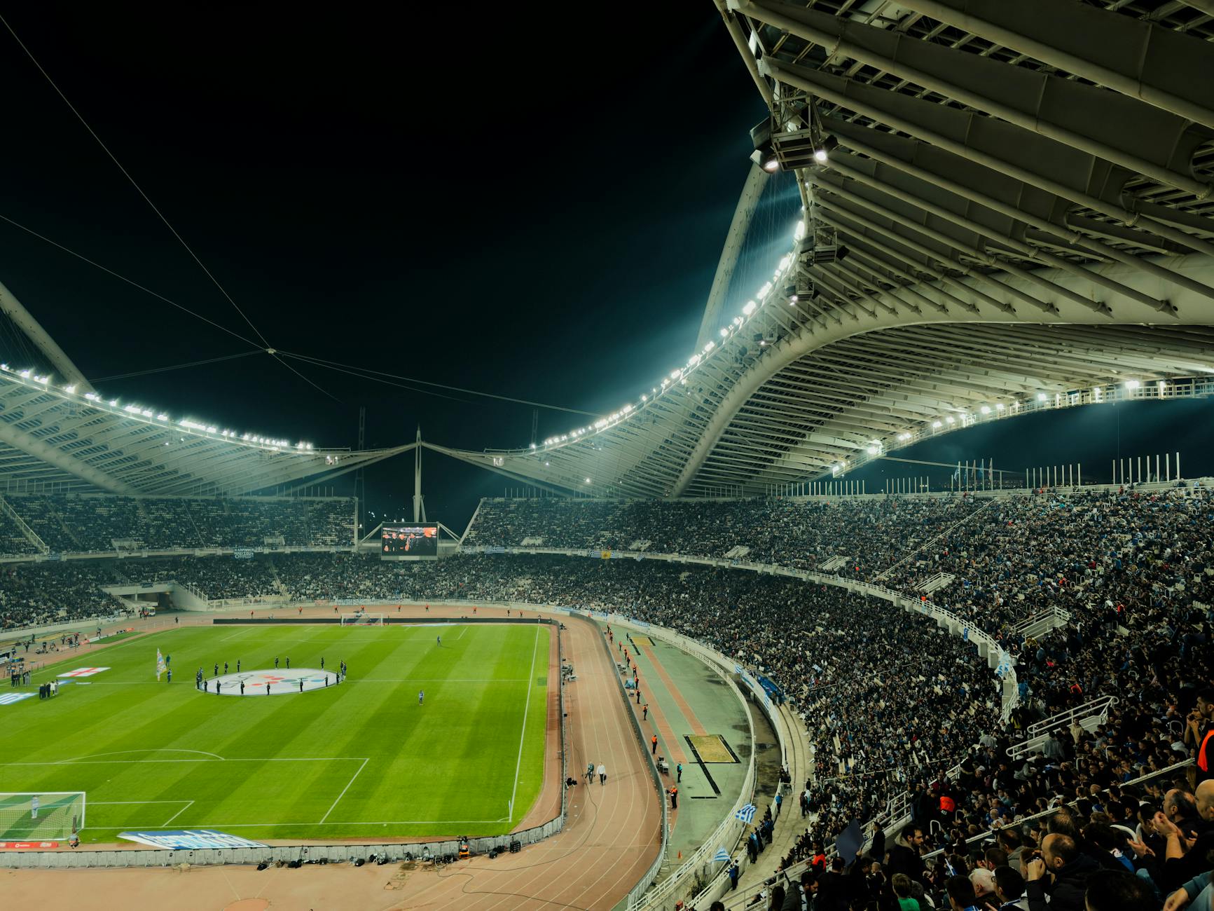 A crowded soccer stadium under bright lights at night, capturing the excitement of a live sports event.
