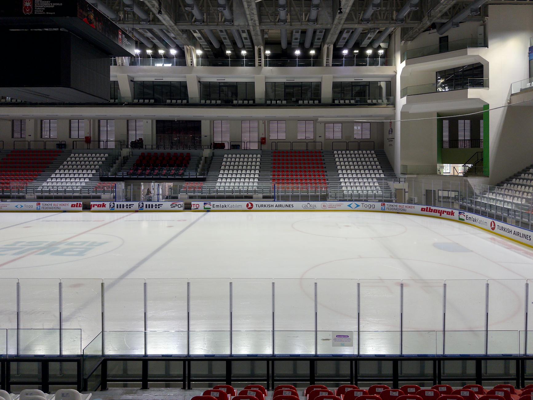 Empty indoor ice rink arena in Istanbul, showcasing stadium seating and ice surface.