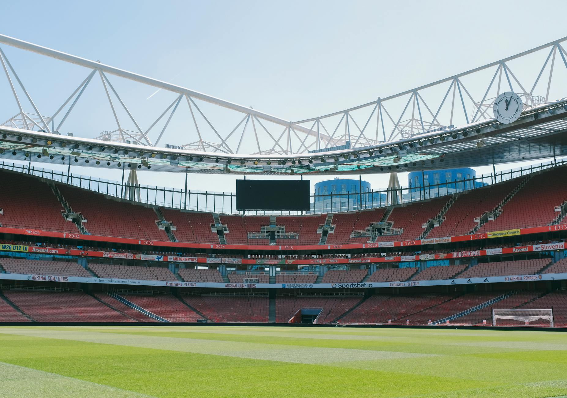 A view of the empty Emirates Stadium, home of Arsenal FC, under a clear sky in London.