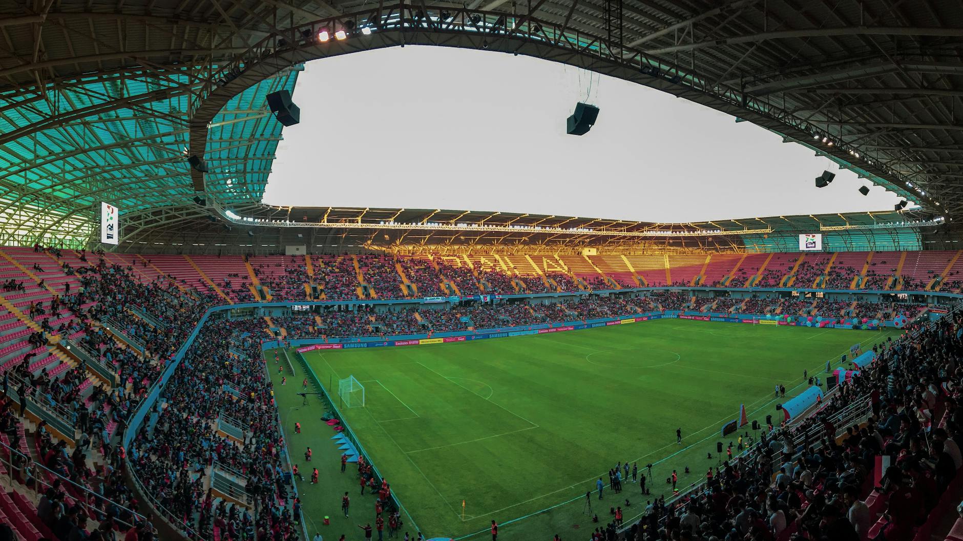 Panoramic view of a bustling soccer stadium filled with enthusiastic fans during a vibrant match.